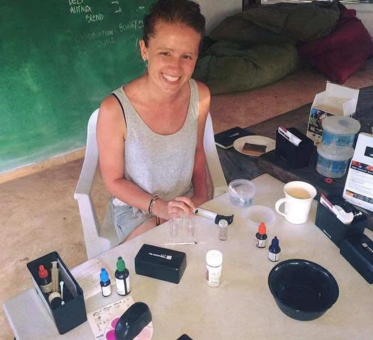 Research intern Rita Naus at a table of water testing kits on base