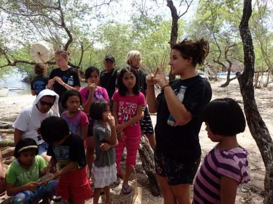 A volunteer engaging with a group of local children during a community outreach activity