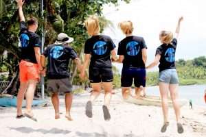 Group of MCP volunteers jumping and celebrating together on the beach