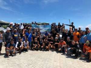 A large group of divers and partners posing in front of a banner