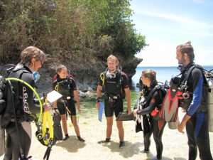 Divers gathered at a rocky shore training site before a confined water dive