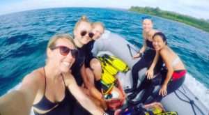 Volunteers taking a group selfie aboard MCP's speedboat on the water