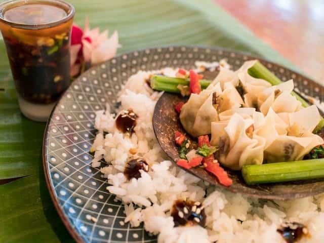 Vegetarian siomai with rice and sauce, served on a banana leaf