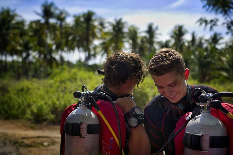 Two dive interns checking their equipment on the beach